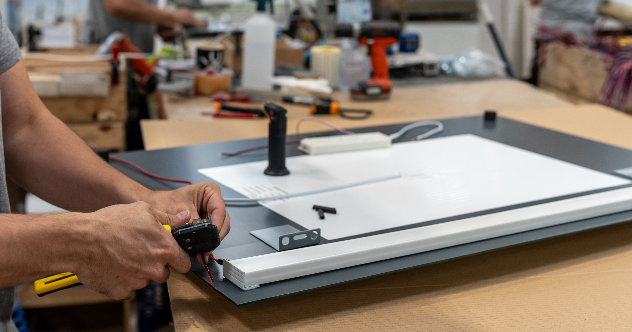 Montaje de espejo de baño con iluminación integrada en taller, mostrando conexión eléctrica y componentes técnicos.